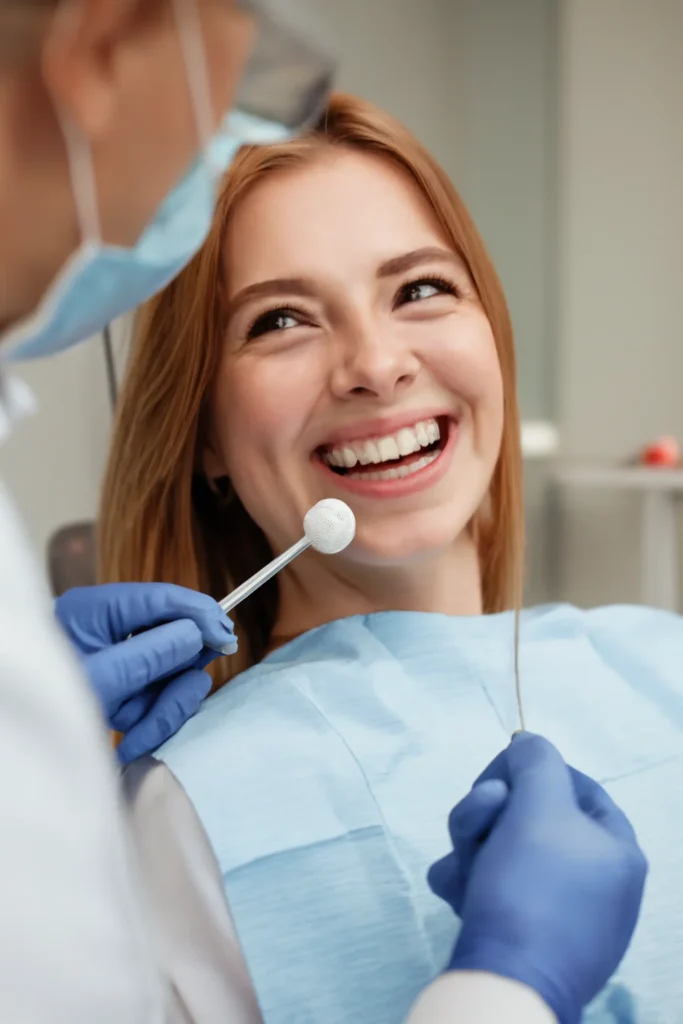 Smiling patient receiving dental care at a dental clinic in Gomti Nagar, with a dentist examining her teeth in a modern, well-lit office.